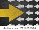 Small photo of Going your own way on asphalt background. The yellow arrrow is moving against the mainstream