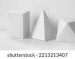 Small photo of Platonic solids figures geometry. Abstract white color geometrical figures still life composition. Three-dimensional prism pyramid rectangular cube objects on gray background.