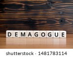 Small photo of demagogue - word from wooden blocks with letters, populist exciting the emotions demagogue concept, random letters around, white background