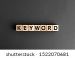 Keyword - word from wooden blocks with letters, search information that contains that word keyword concept, random letters around, white  background