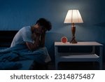 Sleepless, man suffering from insomnia, sleep apnea or stress. Tired and exhausted guy. Headache or migraine. Awake in the night. Frustrated person with problem. Copy space