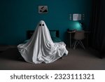 White ghost sitting on bed in bedroom, halloween concept. Place for text