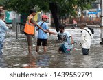 Small photo of Mumbai / India 01 July 2019 A municipal worker helps pedestrians wade through water-logged on streets after heavy rainfall at Mumbai Maharashtra India