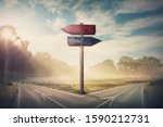 Small photo of Surreal landscape with a split road and signpost arrows showing two different courses, left and right direction to choose. Road splits in distinct direction ways. Difficult decision, choice concept.
