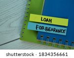 Small photo of Loan Forbearance write on sticky notes isolated on office desk. Selective focus on Loan Forbearance