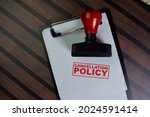 Red Handle Rubber Stamper and Cancellation Policy text isolated on wooden table.