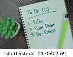 Small photo of Concept of To Do List : Relax, Slow Down, De-Stress write on a book isolated on Wooden Table.