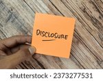 Small photo of Concept of Disclosure write on sticky notes isolated on Wooden Table.