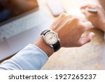 looking at luxury watch on hand check the time writing business information in notepad at workplace.concept for managing time organization working,punctuality,appointment.fashionable wearing stylish