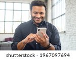 Small photo of Positive indian guy using smartphone for online communication, smiling mixed-race guy browsing, scrolling news feed, messaging in social media,hindu man holds phone and enjoying new mobile application