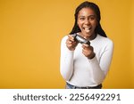 Small photo of Photo of happy excited crazy smiling woman playing videogames addicted to playstation isolated on yellow colour background