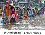 Small photo of Dhaka, Bangladesh - July 21, 2020: Vehicles try to drive through a flooded street in Dhaka. Encroachment of canals is contributing to the continual water logging in Dhaka, Bangladesh on July 21, 2020.