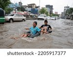 Small photo of Dhaka, Bangladesh - June 18, 2011: Vehicles try to drive through a flooded street in Dhaka, Bangladesh. Encroachment of canals is contributing to the continual water logging in Dhaka, Bangladesh.