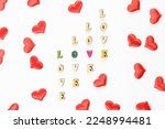 Inscription love made of wooden letters with hearts for Valentines Day. Festive hearts for declaration of love and strong relationship.