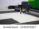 Small photo of Digital die cutter machine cutting PP flute board. Industrial manufacture.