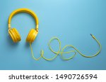 Yellow headphones on blue background. Music concept.