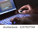 Man installing software in laptop in dark at night. Hacker loading=
