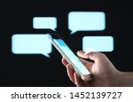 Text messages in cellphone screen with abstract hologram speech bubbles. Instant messaging app. Texting, group chat, sexting or sms concept. Customer service help desk with live support chatbot.