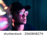 Small photo of Futuristic neon technology. Man with glasses in future cyberpunk illumination. Purple fluorescent color on face. Studio portrait. Techno rave party or night club disco. Bokeh flare and light leak.