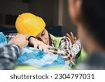 Small photo of Foreman user radio to nurse for first aid Construction worker faint in construction site because Heat Stroke. Worker with safety helmet take a nap because so are tired from working in the hot sun