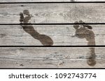 Small photo of Wet footprints on a wooden jetty / bridge. Concept for swimming / bath, summer holidays / vacation, fun in the sun, etc. Fullscreen texture.