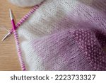 Small photo of Details of pink and white ombre mohair hand knitted sweater with stitches including stocking stitch and moss or seed stitch, knitted on circular needles.