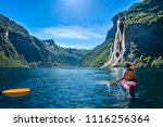 young man kayaking along the fjord geiranger enjoying the waterfall 
