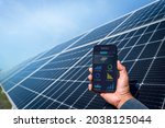 Man hand holding the telephone for monitoring performance in solar power plant(solar cell). Alternative energy to conserve the world's energy, Photovoltaic module idea for clean energy production.
