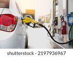 Closeup of people pumping gasoline fuel in car at gas station. Petrol or gasoline being pumped into a motor vehicle car. 