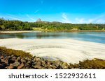 Isle of Eigg, Small Isles, Hebrides, Scotland.  A beautiful bay at low tide with silver sands and An Sgurr in the background.  Landscape, Horizontal, space for copy.