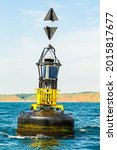Small photo of Portrait of the Filey Brigg Bell Buoy bobbing about in the North Sea, off the seaside resort of Filey in North Yorkshire, UK. Clean, blue sky background. Vertical, space for copy.
