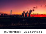 Small photo of Silhouette of a power station against a beautiful winter sunrise near Drax in North Yorkshire, UK, with plumes of water vapour rising from the cooling towers. Horizontal. Copy space