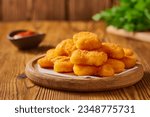Small photo of Portion of freshly cooked homemade nuggets in a wooden plate. Studio shot from a low angle.