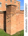 Small photo of Red brick column from a Georgian workhouse wall. Red brick column of an outside wall of an English workhouse.