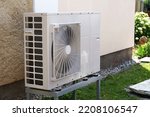 Small photo of Heat pump or air conditioning outdoor unit in modern house of future using green electric energy, heat pump - efficient source of heat