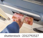 Small photo of Atm cash machine money. Woman withdraw rupiah money from the ATM bank machine