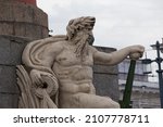 Small photo of SAINT PETERSBURG, RUSSIA 12.08.2021 god of sea and commerce stone sculpture on Rostral Column (architect - Jean-Francois Thomas de Thomon). Side view shot