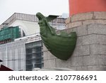 Small photo of SAINT PETERSBURG, RUSSIA 12.08.2021 bronze prow of a ship decoration of the bow with woman goddess figurehead on Rostral Column (architect - Jean-Francois Thomas de Thomon). Side view shot