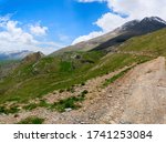 The dirt road passes through green Alpine meadows in the highlands.  Mountain Biking on the national cycle route in the Pyrenees.