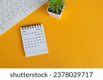Small photo of February 2024 desk calendar on yellow background. Directly above. Flat lay. Copy space.