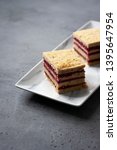 Small photo of Pistachio biscuit layered cake with fresh raspberry, square pieces, grey concrete background, nordic style