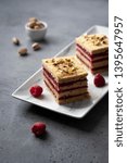 Small photo of Pistachio biscuit layered cake with fresh raspberry, square pieces, grey concrete background, nordic style