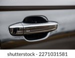 Car door handle with keyless go sensor. Touch sensor for door opening. Automatic opening of a car door without a key. The exterior design of a new black luxury car. Closeup.