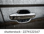 Car door right handle with keyless go sensor. Automatic opening of a car door without a key. The exterior design of a new black luxury car. Closeup.