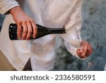 Man pours wine into glasses. The waiter pours prosecco or sparkling champagne. Valentine's day in restaurant. Luxury romantic date. Engagement. Location for surprise marriage proposal. Closeup.