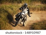 Motorbike rider on track. Strong grain added to create atmosphere, outdoor shot.
