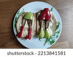 Small photo of smoked sprat fish. smoked sprat sandwich. a funny sprat sandwich that looks like a woman's legs in a short skirt and boots
