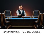 Male croupier at the poker table, poker room. Poker game, casino, Texas hold'em, online game, card games. Modern design, magazine style