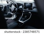 Modern black car interior, leather steering wheel, climate control, navigation, air ducts, deflectors on the car panel. Details interior. 