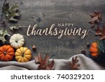 Happy Thanksgiving script with pumpkins and leaves over dark wooden background